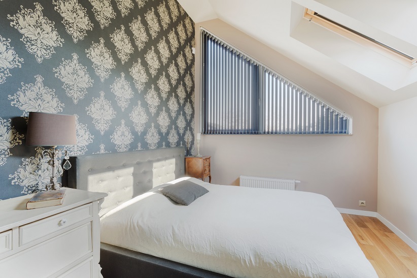 Bedroom with fancy design wallpaper and wood floors