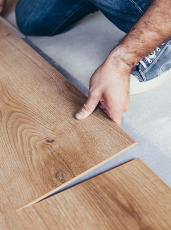 man putting wood flooring planks together