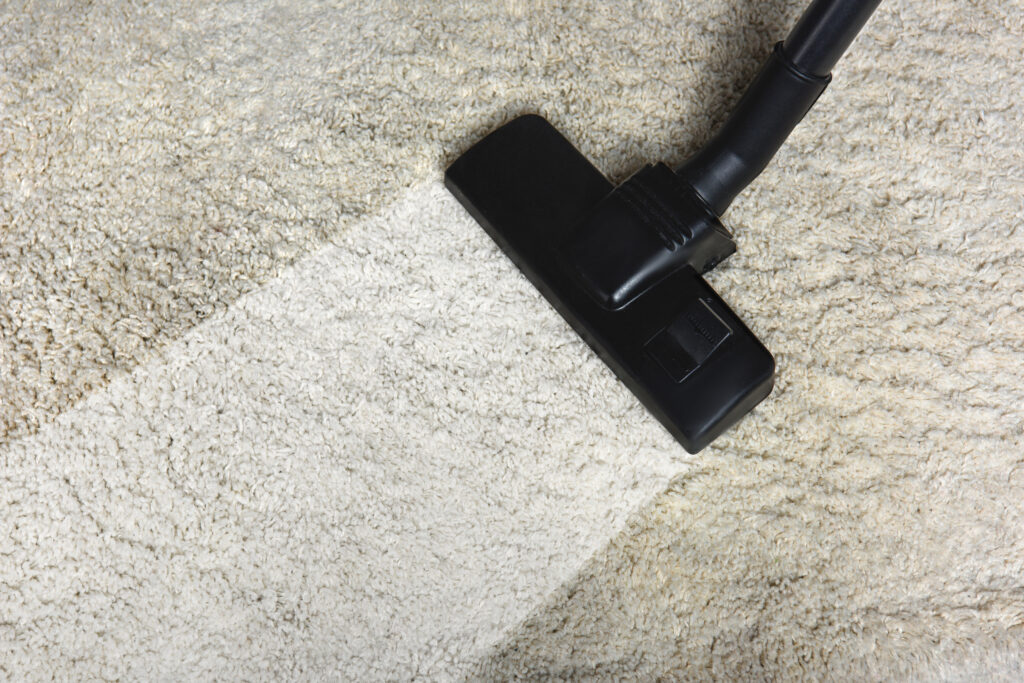 Close-up view of cleaning white carpet with professional vacuum cleaner