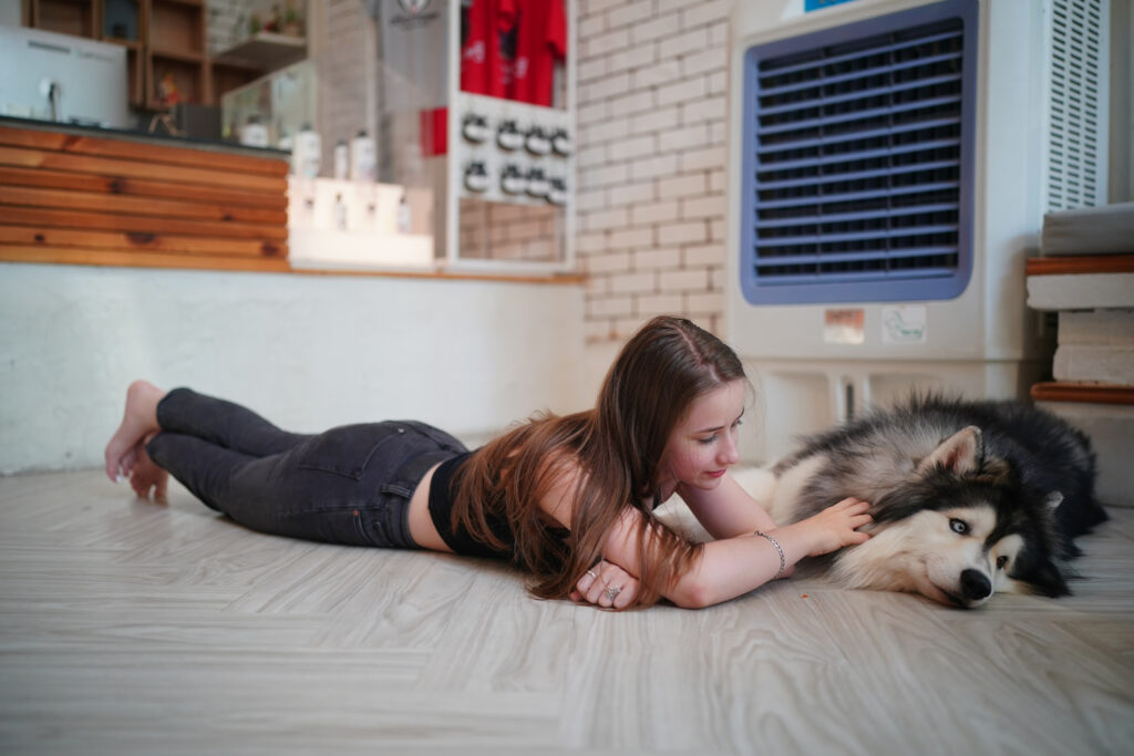 Young woman with her dog at modern house on nature light.