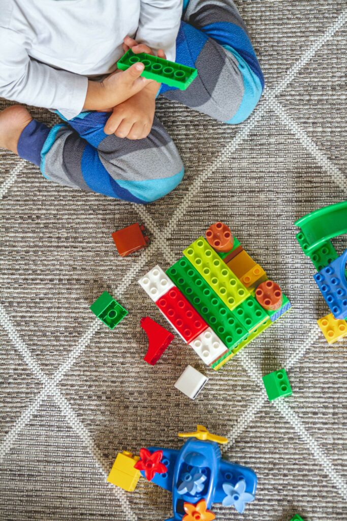 child playing with toys on carpet