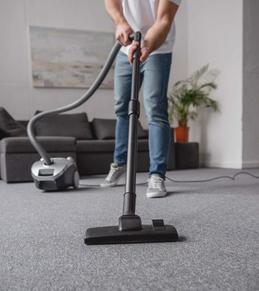 man vacuuming carpet