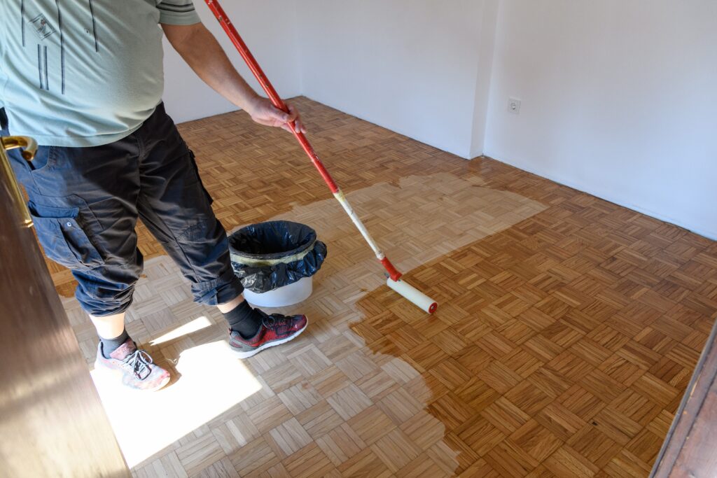 man-applying-lacquer-finish-on-oak-hardwood-floor-2023-11-27-05-00-29-utc
